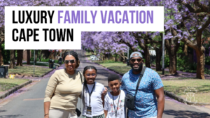 African American family smiling and posing on a tree-lined street with purple jacaranda blossoms during their luxury family vacation in Cape Town.